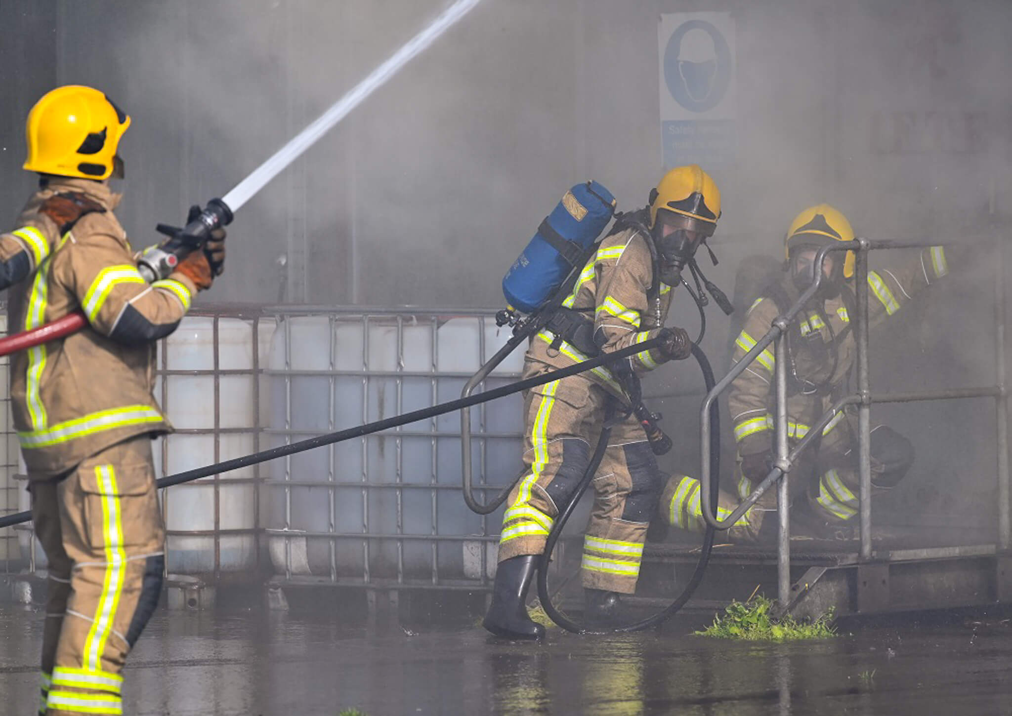 Firefighters in training with fire hose