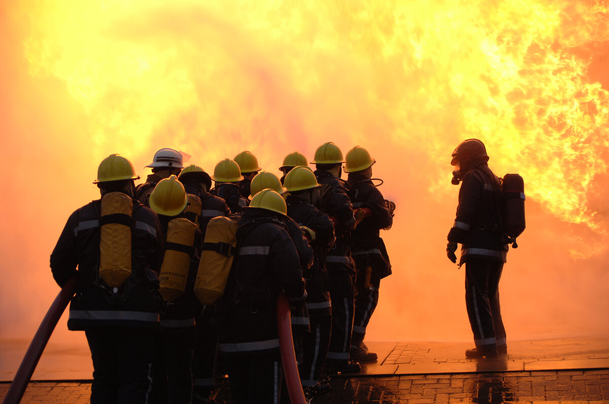 Firefighter training group dousing flames