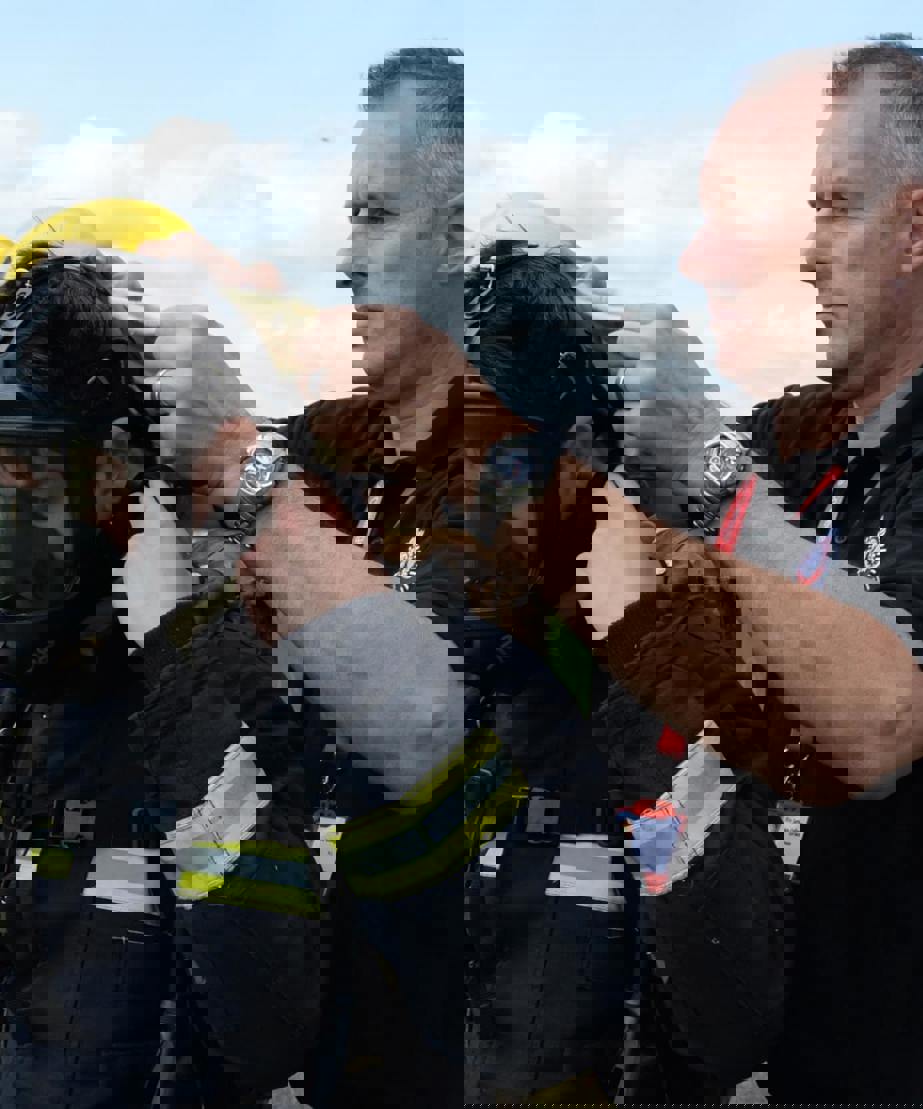 Instructor fitting trainee with breathing apparatus