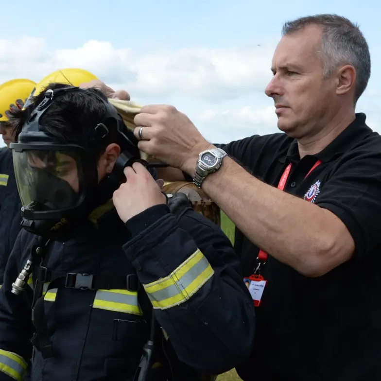Instructor fitting trainee with breathing apparatus Instructor fitting trainee with breathing apparatus