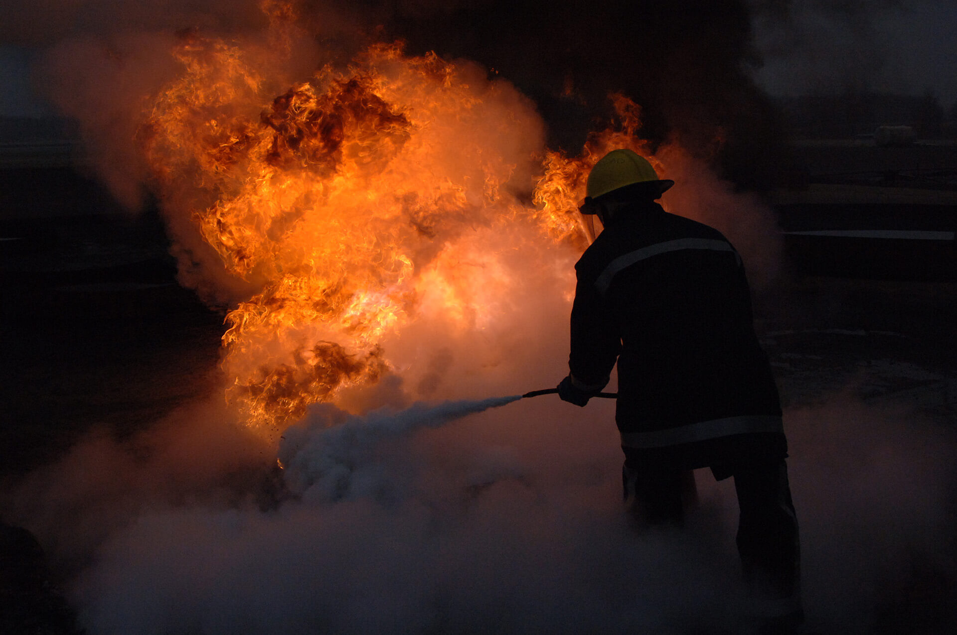 Firefighter dousing a fire with a fire hose